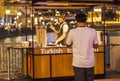 Person approaching Turkish ice cream stall. Outdoors