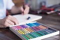 Person, artist painting with a pastel crayon chalk on sketchbook on wooden table, selective focus Royalty Free Stock Photo