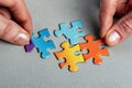 Person assembles puzzle using colorful pieces