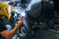 Man working with welding machine on wheel arch cover