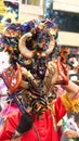 Person in a black devil mask with a headdress