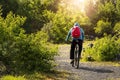 Person in blue hoodie and red backpack riding a bike in a country side. Cross country cycling concept. Adventure and outdoor Royalty Free Stock Photo