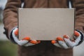 Person in brown coat holding simple paper cardboard package