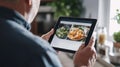 Person browsing food photos on tablet screen in modern kitchen Royalty Free Stock Photo