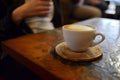 person at a caf, a coaster with a cappuccino cup on top