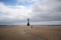 person, capturing the solitary beauty of a lighthouse on an empty beach
