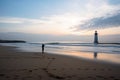 person, capturing the solitary beauty of a lighthouse on an empty beach