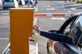 Person in the car inserting into or removing ticket from parking vending machine. Paying, entering parking lot or Royalty Free Stock Photo