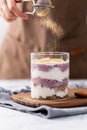 Person is carefully adding a layer of cocoa powder to a luscious blueberry trifle Royalty Free Stock Photo