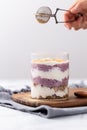 Person is carefully adding a layer of cocoa powder to a luscious blueberry trifle Royalty Free Stock Photo