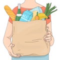 Unrecognizable person carries a paper bag from a supermarket with products. Groceries, fruits, vegetables.