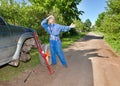 The person changes a wheel at the car by means of a red rack jack Royalty Free Stock Photo