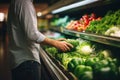 Person choosing fresh vegetables in supermarket