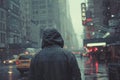 A person clad in a hooded jacket, back facing the camera, walks alone on a snowy city street,