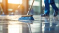 Person cleaning the floor with a blue broom