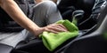 The person cleaning the interior of a car with a green microfiber cloth. AI generated image Royalty Free Stock Photo