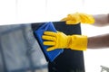 Person cleaning room, cleaning worker is using cloth to wipe computer screen in company office room. Cleaning staff. Concept of Royalty Free Stock Photo