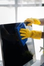 Person cleaning room, cleaning worker is using cloth to wipe computer screen in company office room. Cleaning staff. Concept of Royalty Free Stock Photo