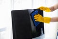 Person cleaning room, cleaning worker is using cloth to wipe computer screen in company office room. Cleaning staff. Concept of Royalty Free Stock Photo