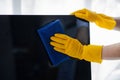 Person cleaning room, cleaning worker is using cloth to wipe computer screen in company office room. Cleaning staff. Concept of Royalty Free Stock Photo