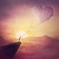 A person on the cliff and a heart shaped cloud like a kite raising up in the air. Magical scene, love and romance concept. Pink