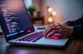 Person coding on laptop at home office. Person types on laptop keyboard. Person working on software project. Person using home