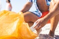 Person collects trash on a sunny beach Royalty Free Stock Photo