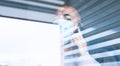 Man confined to his home protected from the coronavirus virus behind the window pane talking on the phone with a protective mask Royalty Free Stock Photo