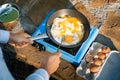 Person cooking eggs on camping stove Royalty Free Stock Photo