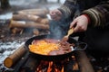 person, cooking breakfast of pancakes and bacon over campfire Royalty Free Stock Photo