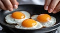 A person is cooking eggs in a frying pan with two fried, AI Royalty Free Stock Photo