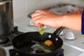 Person cooking eggs in a pan