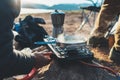 Person cooking hot drinks in nature camping outdoor, cooker prepare breakfast picnic on metal gas stove, tourism recreation