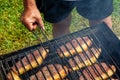 Person cooking steaks on a barbecue grill