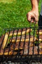 Person cooking steaks on a barbecue grill