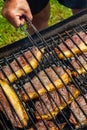 Person cooking steaks on a barbecue grill