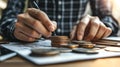 Person counting coins on a financial report, close-up view