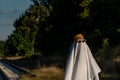 Person covered by white sheet, with sunglasses and hat,in appearance of ghost, in Guadalajara Mexico