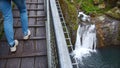 Person crossing a high bridge over a waterfall Royalty Free Stock Photo