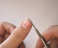 A person cuts his nails with small scissors. Men`s manicure. A man cuts off a large overgrown nail