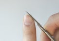 A person cuts his nails with small scissors. Men`s manicure. A man cuts off a large overgrown nail