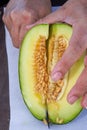 A person is cutting cantaloupe, close-up of cantaloupe slices