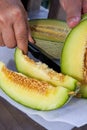 A person is cutting cantaloupe, close-up of cantaloupe slices