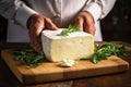 A person cutting cheese on a cutting board. Farmer or chef makes cheese slice