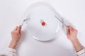 Person Cutting Cherry Tomato On Plate