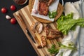 person cutting cooked or grilled beef steak with a knife on a wooden boards