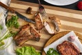 person cutting cooked or grilled beef steak with a knife on a wooden boards