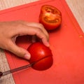 A person cutting a piece of food. Sliced tomato. Royalty Free Stock Photo