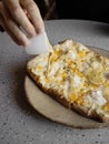 a person cutting a pizza on a paper plate Royalty Free Stock Photo