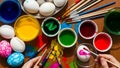 Person decorating easter eggs with paints and brushes on desk Royalty Free Stock Photo